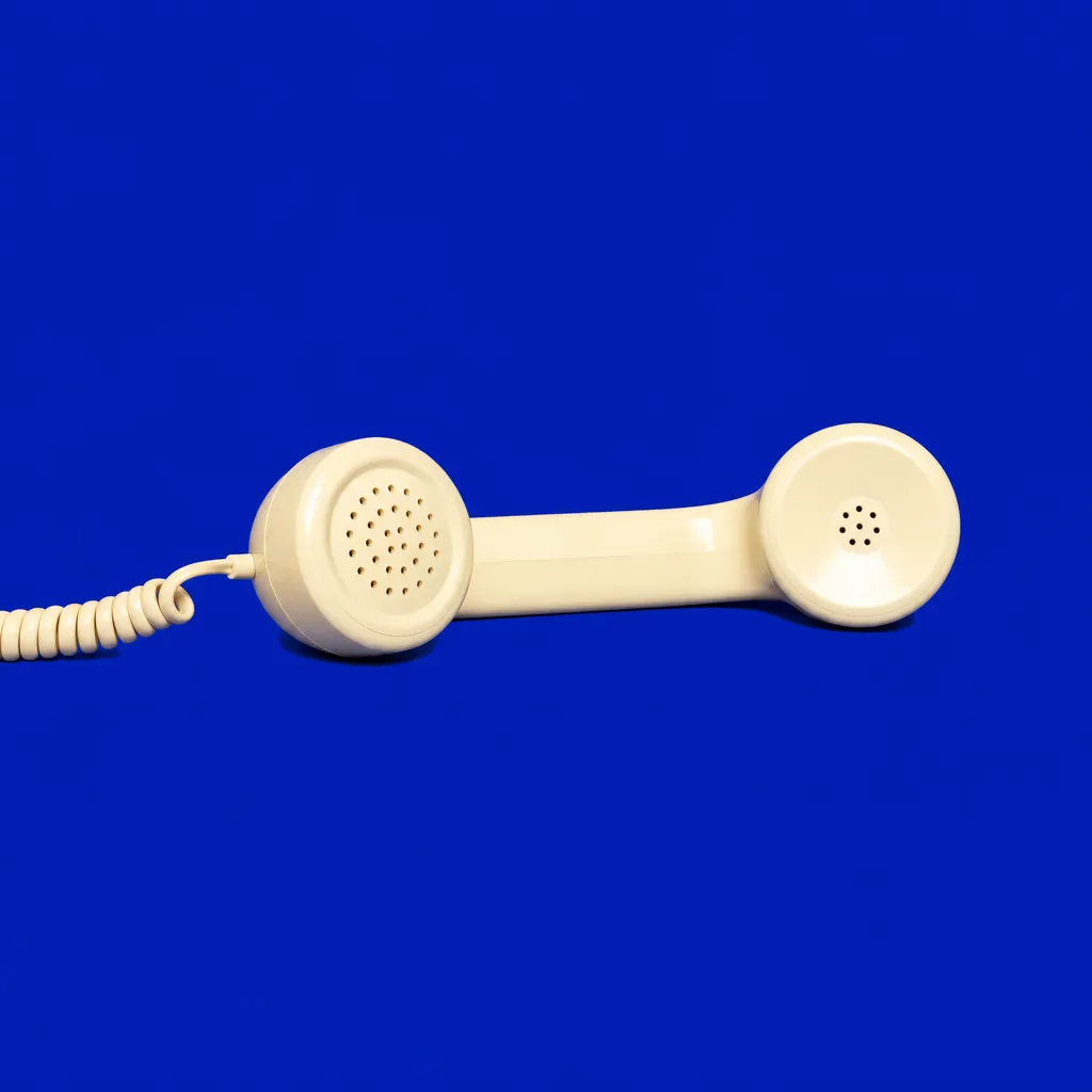 A cream telephone handset on blue